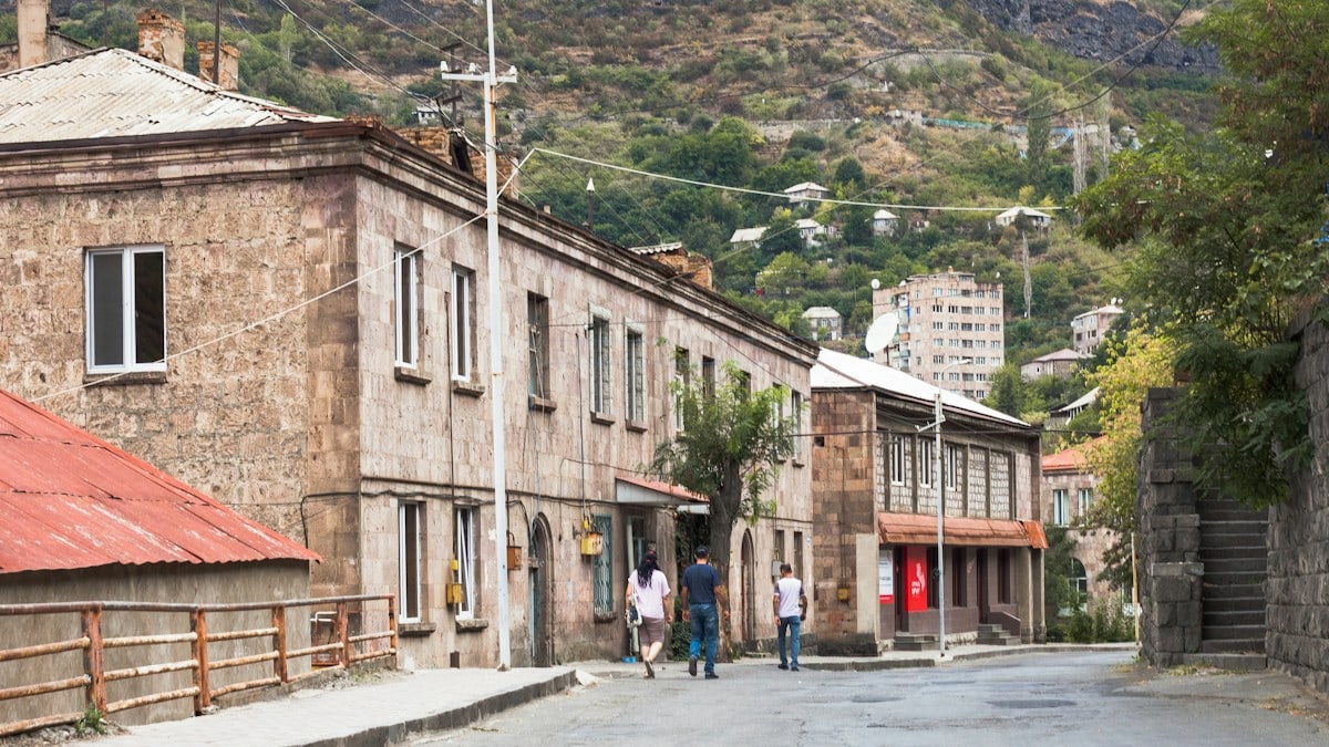 a group of people walking down a street next to buildings
